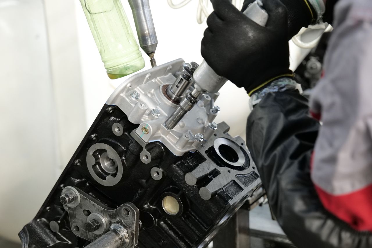 The Art of Drawing Readers In: Your attractive post title goes here Skilled mechanic working on engine assembly with precision tools in factory setting.