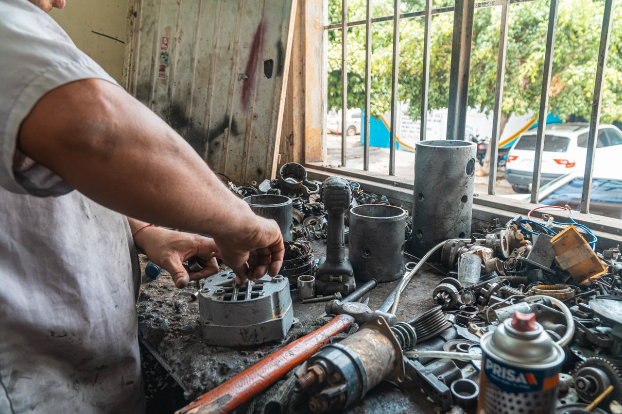 Mastering the First Impression: Your intriguing post title goes here Close-up of a mechanic's hands working with car parts on a workshop table.
