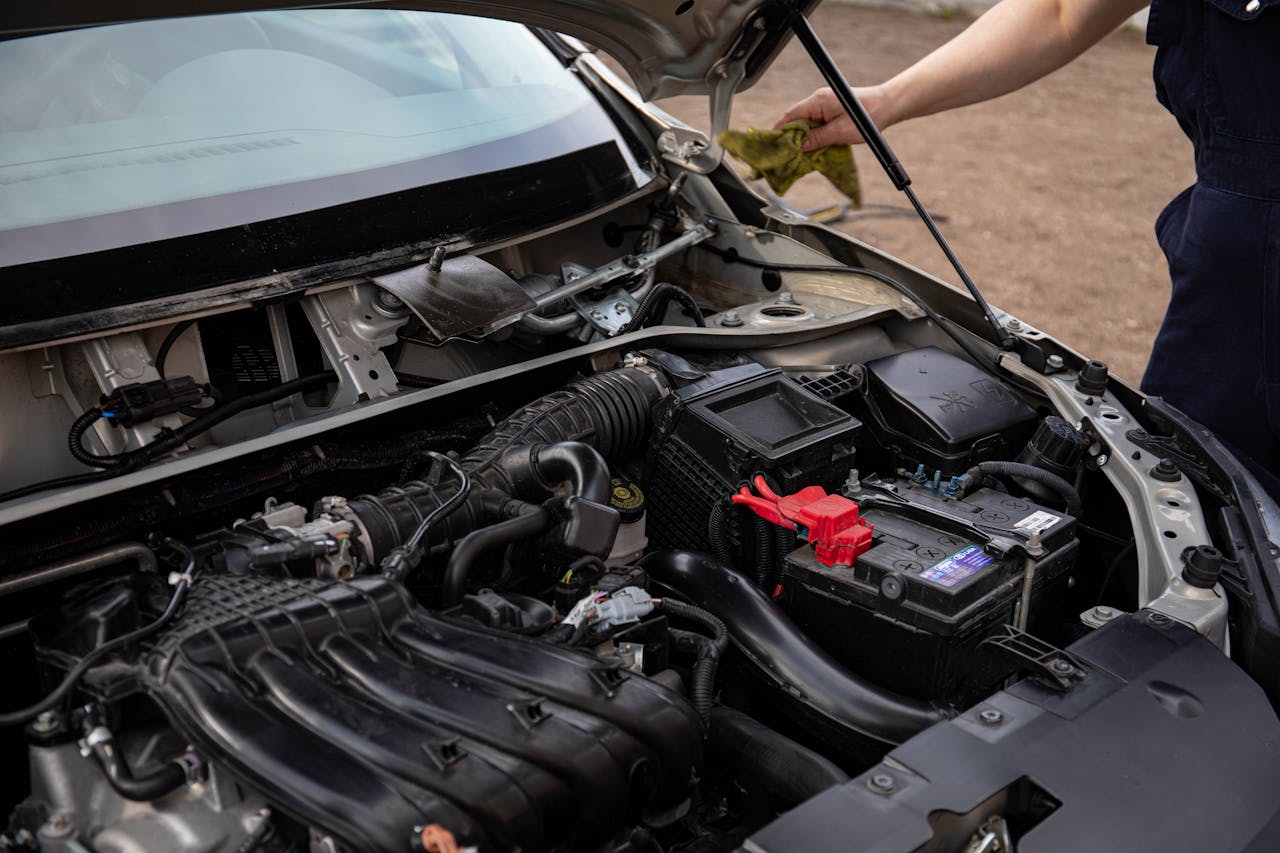 Crafting Captivating Headlines: Your awesome post title goes here Mechanic inspecting car engine bay and battery during routine maintenance.